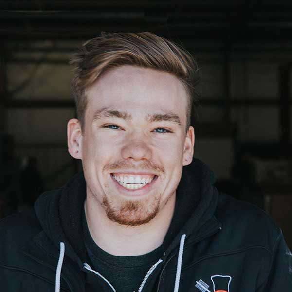 Jonah Lindley CSIA certified chimney technician wearing jacket with logo has a goatee and mustache with nice smile